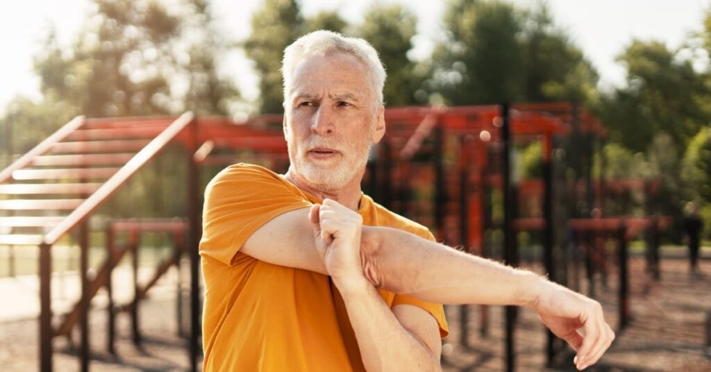 Älterer Mann beim Aufwärmen im Freien – regelmäßige Bewegung als Teil eines gesunden Lebensstils bei Gicht.