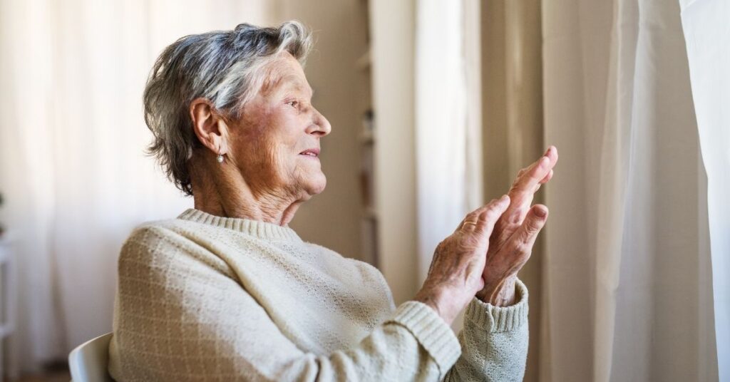 Ältere Frau hält schmerzendes Handgelenk – Gelenkschmerzen können ein Hinweis auf einen akuten Gichtanfall sein.