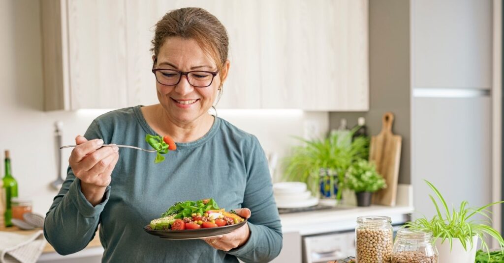 Frau bereitet eine Mahlzeit zu – bewusste Lebensmittelauswahl und purinarme Ernährung bei Gicht im Alltag.